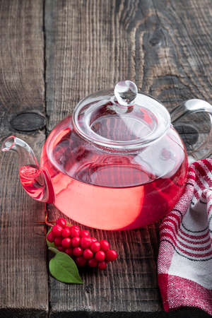 Schisandra tea in clear glass tea pot on wooden tableの写真素材