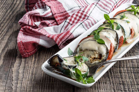 Baked vegetables with cheese and greek basil on wooden tableの写真素材