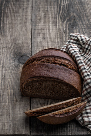 Homemade dark rye bread on rustic wooden table