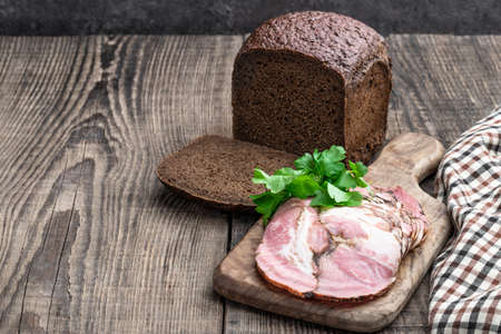 Pork brisket slices smoked meat on rye bread on wooden tableの写真素材