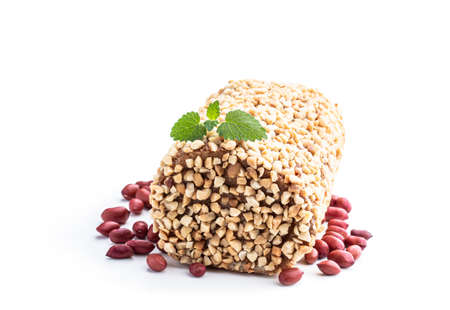 Sponge cake roll covered with nuts isolated on white backgroundの写真素材