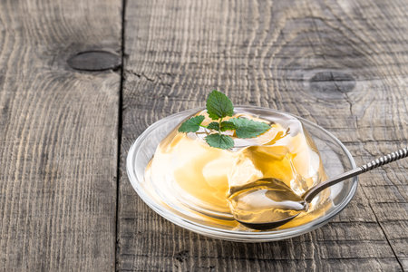 Fruit yellow jelly with fresh fruit on wooden table