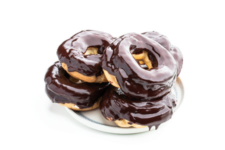 Ring-shaped dark chocolate covered eclairs isolated on whiteの写真素材
