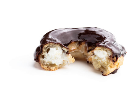 Ring-shaped dark chocolate covered eclair isolated on white