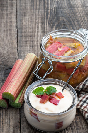 Homemade creamy yoghurt with rhubarb jam on wooden tableの写真素材