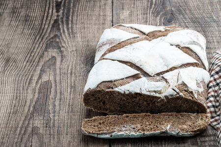 Fresh homemade whole rye spelt meal bread on wooden table