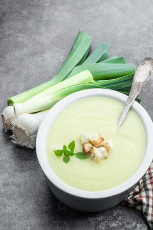 Homemade cream leek soup with croutons on gray backgroundの写真素材