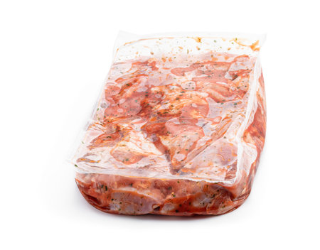 Raw marinated chicken meat in vacuum packaging on a white backgroundの写真素材
