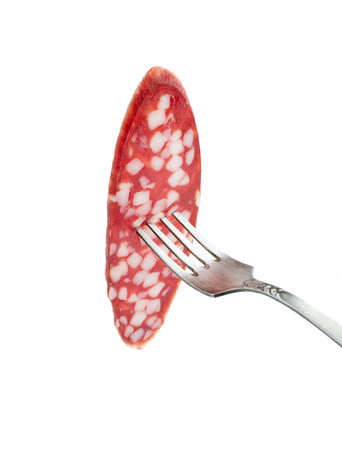 Sliced salami smoked sausage on fork isolated on white backgroundの写真素材