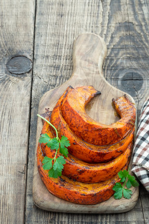 Peace of baked butternut squash pumpkin with honey and cinnamon on wooden tableの写真素材