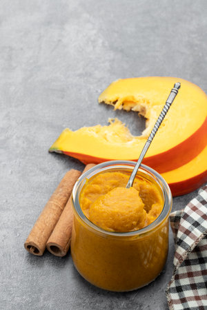 Pumpkin pudding with sweet cream and cinnamon powder on gray backgroundの写真素材