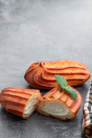 Eclairs with whipped cream on gray background