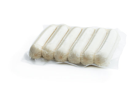 Raw thin chicken sausages in a vacuum package isolated on whiteの写真素材