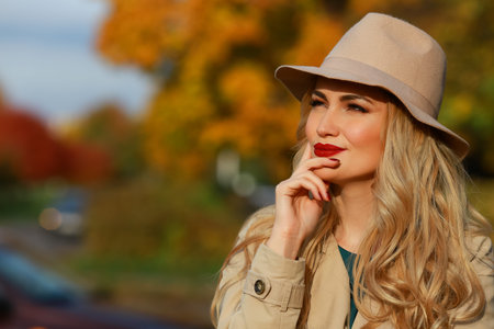 Beautiful woman thinks. Consept autumn. yellow maple garden background. close-up portrait.の写真素材