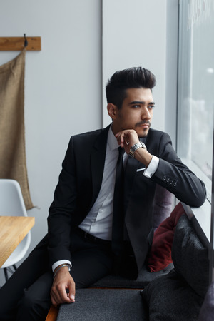 successful man sits and looks out the windowの写真素材