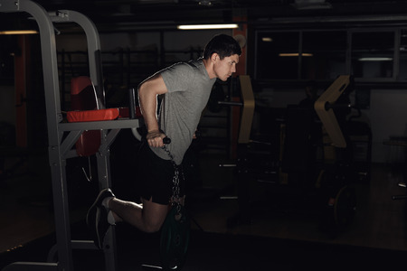 Muscular bodybuilder working out in gym doing exercises parallel bars. Concept sportの写真素材