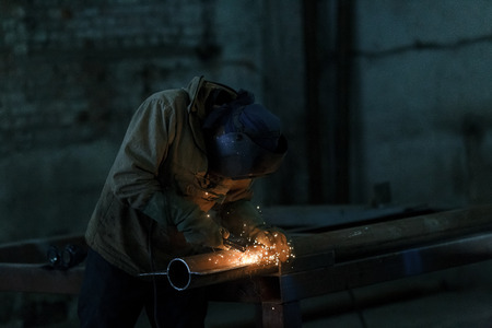 worker welding metal with sparks at factoryの写真素材