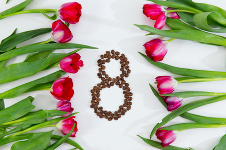 Spring flowers, fresh tulips and coffee beans on white background. Gift on 8 march, womens day.
