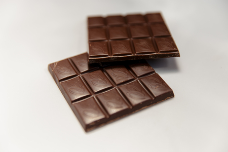 Broken chocolate isolated on white table. Horizontal composition. Top viewの写真素材