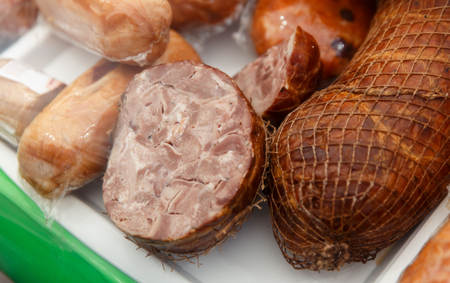 The variety of fresh smoked meat products lying on a stand at the fair.の写真素材