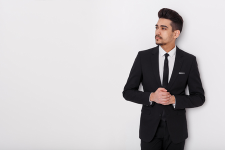 Young businessman in black suit on a white background. Confident man looking away from the camera. copyspaceの写真素材