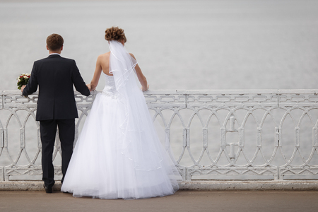 Happy wedding couple standing on river background. copy spaceの写真素材