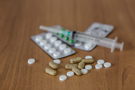 Syringe with many drugs and on wooden table. selective focus