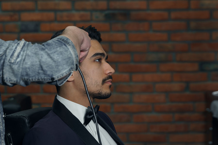 man in suit getting haircut at barbershop.の写真素材