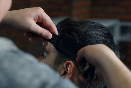 man in suit getting haircut at barbershop.の写真素材