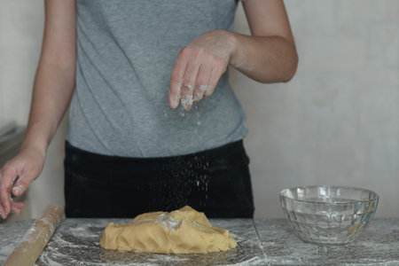 Baker kneading dough in flour on table, slow motion