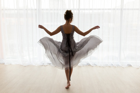 Sexy woman in transparent dress against window, back view, room in white tones on backgroundの写真素材
