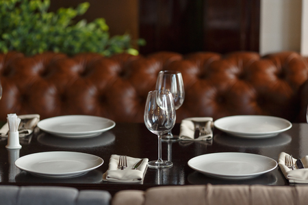Glasses, fork, knife served for dinner in luxury restaurant with cozy interior.の写真素材