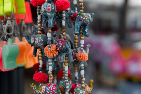 Souvenir shop, showcase with keychains and trinkets with little decorative elephants closeup. Gift market, nobodyの写真素材