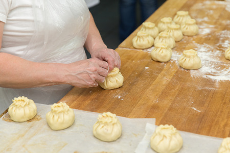 Cook cooks small pies in production, dough.の写真素材