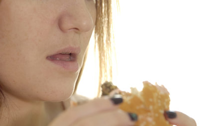 Young woman eating appetizing burger. concept unhealthy food.