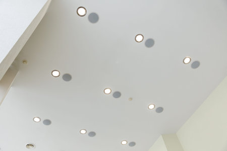 Modern multi-layered ceiling with a large number of built-in lamps.の写真素材