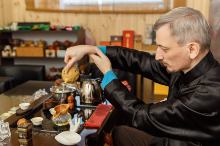 Tea ceremony. Tea maker pours boiling water into the teapot.の写真素材