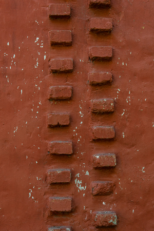 red wall background with withered paint. Old plaster texture.の写真素材