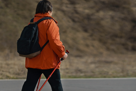 Adult woman on a walk is engaged in Scandinavian walking, copyspaceの写真素材