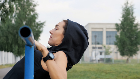 Fitness woman workout doing exercises on a horizontal bar outdoors, copyspaceの写真素材