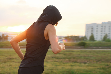 unknown young woman running at the stadium outdoor, back viewの写真素材