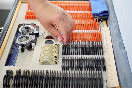 Optometrist takes test glasses for eyes to check vision in the clinic.の写真素材
