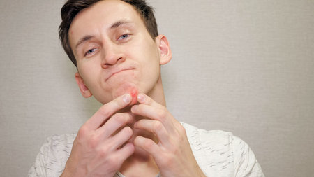 Young man checking his skin, copy space