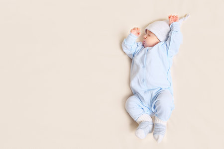 From above shot of lovely baby sleeping on soft bed at home, copy space