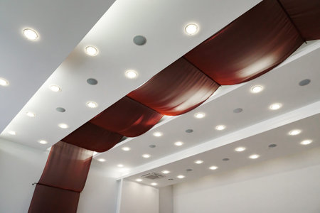 Modern layered ceiling with embedded lights and red cloth.