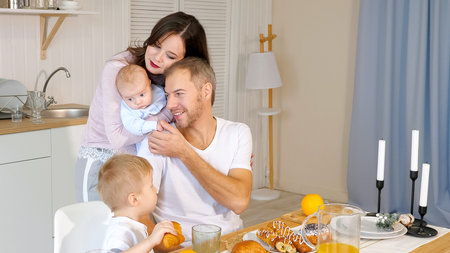 happy mother, father and son having breakfast at home.