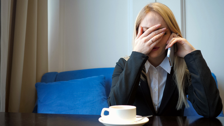Young girl feels sad and crying while speaking with someone on cellphone, close upの写真素材