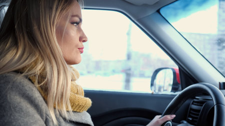 Young adult woman driving car on highway during day time, close up