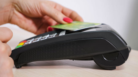 Woman with card is using the terminal for payment, non-cash transaction, terminal issues a check,...