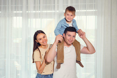 happy family mother father and child son against the background of panoramic windows looking at...